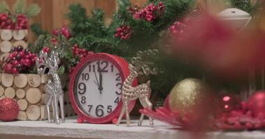 Pink shiny clocks between silver christmas deer toys in front of the christmas tree video