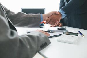 customer and car dealer shake hands after agreeing to sales contract before making contract payment and handing over car keys to customer. concept of handshake between customers and car dealers. photo