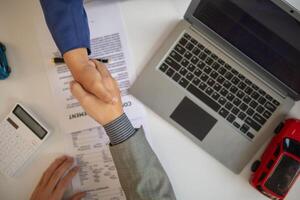 customer and car dealer shake hands after agreeing to sales contract before making contract payment and handing over car keys to customer. concept of handshake between customers and car dealers. photo