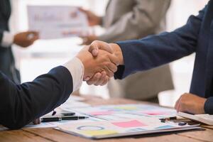 committee of businessmen and investors join hands as symbol of joint investment after discussing consulting and making contract  invest in business together. committee joins hands in meeting. photo