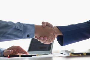 Businessmen and investors shake hands as symbol of joint venture after discussing, consulting and making contract to invest in business together. business people shaking hands as symbol of cooperation photo