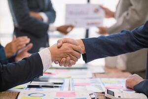 committee of businessmen and investors join hands as symbol of joint investment after discussing consulting and making contract  invest in business together. committee joins hands in meeting. photo