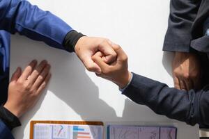 Businessmen and investors shake hands as symbol of joint venture after discussing, consulting and making contract to invest in business together. business people shaking hands as symbol of cooperation photo