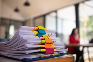 The pile of documents on the secretary's desk was prepared for the executives who would be attending the meeting. Several documents were stacked on the secretary's desk ready for the attendees. photo