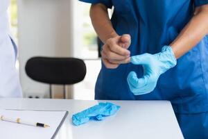 doctor is wearing blue rubber gloves prevent direct contact with patient because virus may be traced to patient body and medical rubber gloves also help prevent virus from being transmitted to patient photo