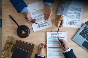 Businessmen and investors discussed joint venture within the legal counsel office and agreed to sign a contract in front of the lawyers within the legal counsel office to witness the joint investment. photo