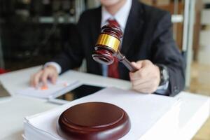 judge holds givel wood tapped on the wooden base to read verdict for victims and defendants to know the verdict obtained from the evidence and the lawyer's defense of the case. court decision concept photo