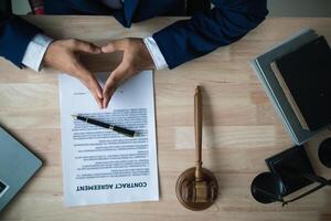 contract was placed on table inside legal counsel's office, ready for investors to sign the contract to hire a team of lawyers to provide legal advice for their investment. legal consulting concept photo