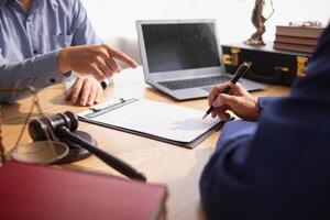 contract was placed on table inside legal counsel's office, ready for investors to sign the contract to hire a team of lawyers to provide legal advice for their investment. legal consulting concept photo