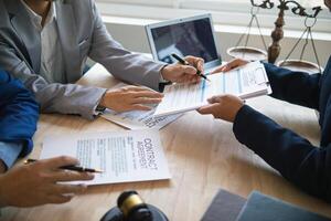 Businessmen and investors discussed joint venture within the legal counsel office and agreed to sign a contract in front of the lawyers within the legal counsel office to witness the joint investment. photo