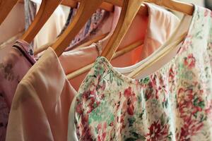 collection of women's clothes hanging on rack photo