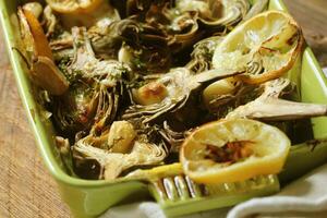fried artichokes with garlic and lemon on pan on rustic table photo