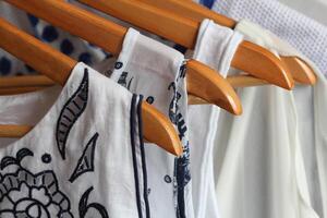 Summer collection of women's clothes hanging on a rack photo