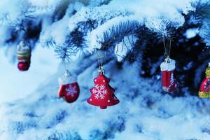natural abeto árbol cubierto con nieve.. Navidad decoración colgando en abeto árbol rama foto