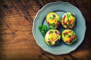 Avocado Egg Boats with bacon on dark wooden background. Top view photo