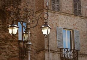 Old street lamp against the wall of building photo