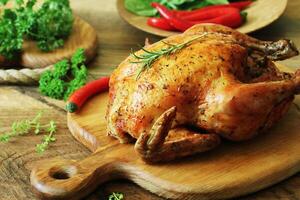 Whole roasted chicken on cutting board photo