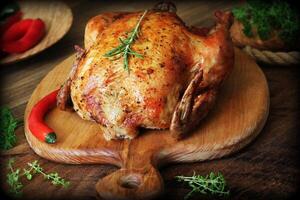 Whole roasted chicken on cutting board photo