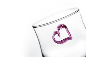 One glass with heart shape in purple color photo