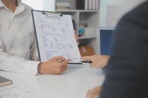 cerca arriba ver de trabajo entrevista en oficina, atención en currículum escritura consejos, empleador revisando bueno CV de preparado experto solicitante, reclutador considerando solicitud, hora gerente haciendo contratación decisión foto