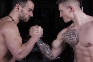 Arm wrestling. Two strong bodybuilders shake hands photo