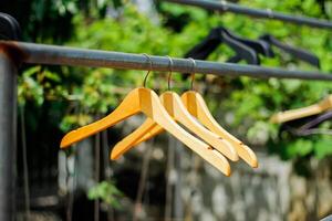 wooden clothes hanger with a natural leafy background in the garden photo