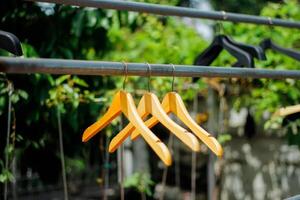 wooden clothes hanger with a natural leafy background in the garden photo