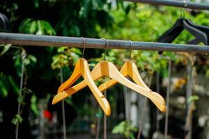 wooden clothes hanger with a natural leafy background in the garden photo