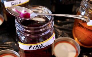 Jar of Pink Easter Egg Dye with Spoon Resting on Top photo