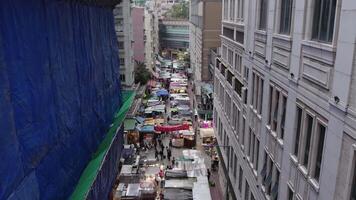 Drönare se en smal gata i hong kong, marknadsföra i de mitten av skyskrapor video