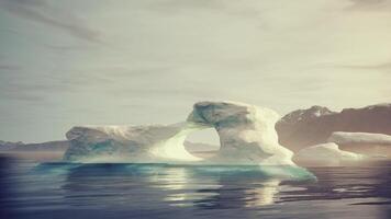 A large iceberg floating in the middle of a body of water video