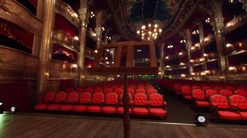 An empty theater with red seats and chandeliers video