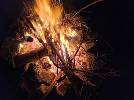 Flames of a stone pit fire at night in dark background at a campground state park in Washington State photo