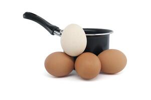 Cooking pot surrounding eggs isolated on white background photo