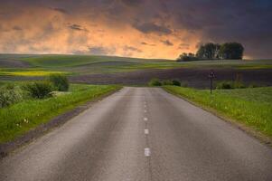 Asphalt road running through countryside landscape photo