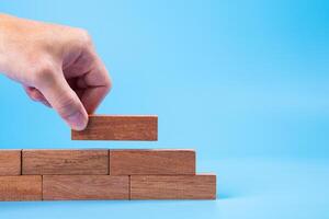 Hand of man piling up and stacking a wooden block. Plan and strategy in business, Risk To Make Business Growth Concept photo