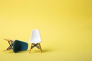 White chair and a blue one falling down. Business concept. photo