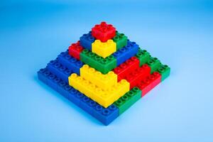 Color plastic building blocks on blue background photo