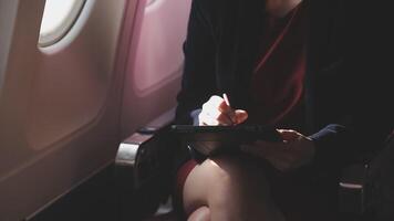 Asian young woman using laptop sitting near windows at first class on airplane during flight,Traveling and Business concept video