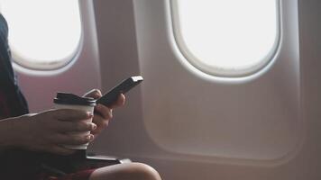 jeune femme asiatique utilisant un ordinateur portable assis près des fenêtres en première classe en avion pendant le vol, les voyages et le concept d'entreprise video