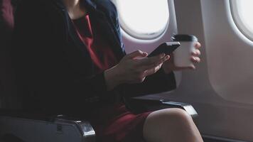 jeune femme asiatique utilisant un ordinateur portable assis près des fenêtres en première classe en avion pendant le vol, les voyages et le concept d'entreprise video