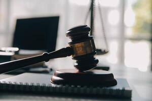 Business and lawyers discussing contract papers with brass scale on desk in office. Law, legal services, advice, justice and law concept picture with film grain effect photo