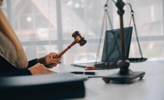 Business and lawyers discussing contract papers with brass scale on desk in office. Law, legal services, advice, justice and law concept picture with film grain effect photo