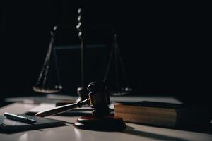 Business and lawyers discussing contract papers with brass scale on desk in office. Law, legal services, advice, justice and law concept picture with film grain effect photo