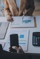 Financial analysts analyze business financial reports on a digital tablet planning investment project during a discussion at a meeting of corporate showing the results of their successful teamwork. photo