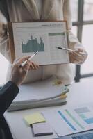 Financial analysts analyze business financial reports on a digital tablet planning investment project during a discussion at a meeting of corporate showing the results of their successful teamwork. photo