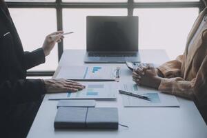 Financial analysts analyze business financial reports on a digital tablet planning investment project during a discussion at a meeting of corporate showing the results of their successful teamwork. photo