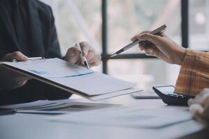 Financial analysts analyze business financial reports on a digital tablet planning investment project during a discussion at a meeting of corporate showing the results of their successful teamwork. photo