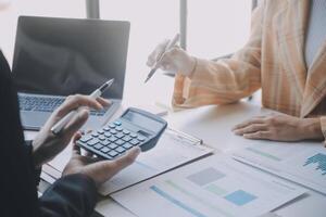 Financial analysts analyze business financial reports on a digital tablet planning investment project during a discussion at a meeting of corporate showing the results of their successful teamwork. photo