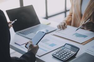 Financial analysts analyze business financial reports on a digital tablet planning investment project during a discussion at a meeting of corporate showing the results of their successful teamwork. photo